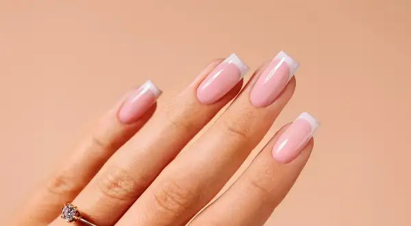 Dłoń z idealnym french manicure. Dowiedz się, jak przygotować płytkę paznokcia pod żel, by uzyskać taki efekt.