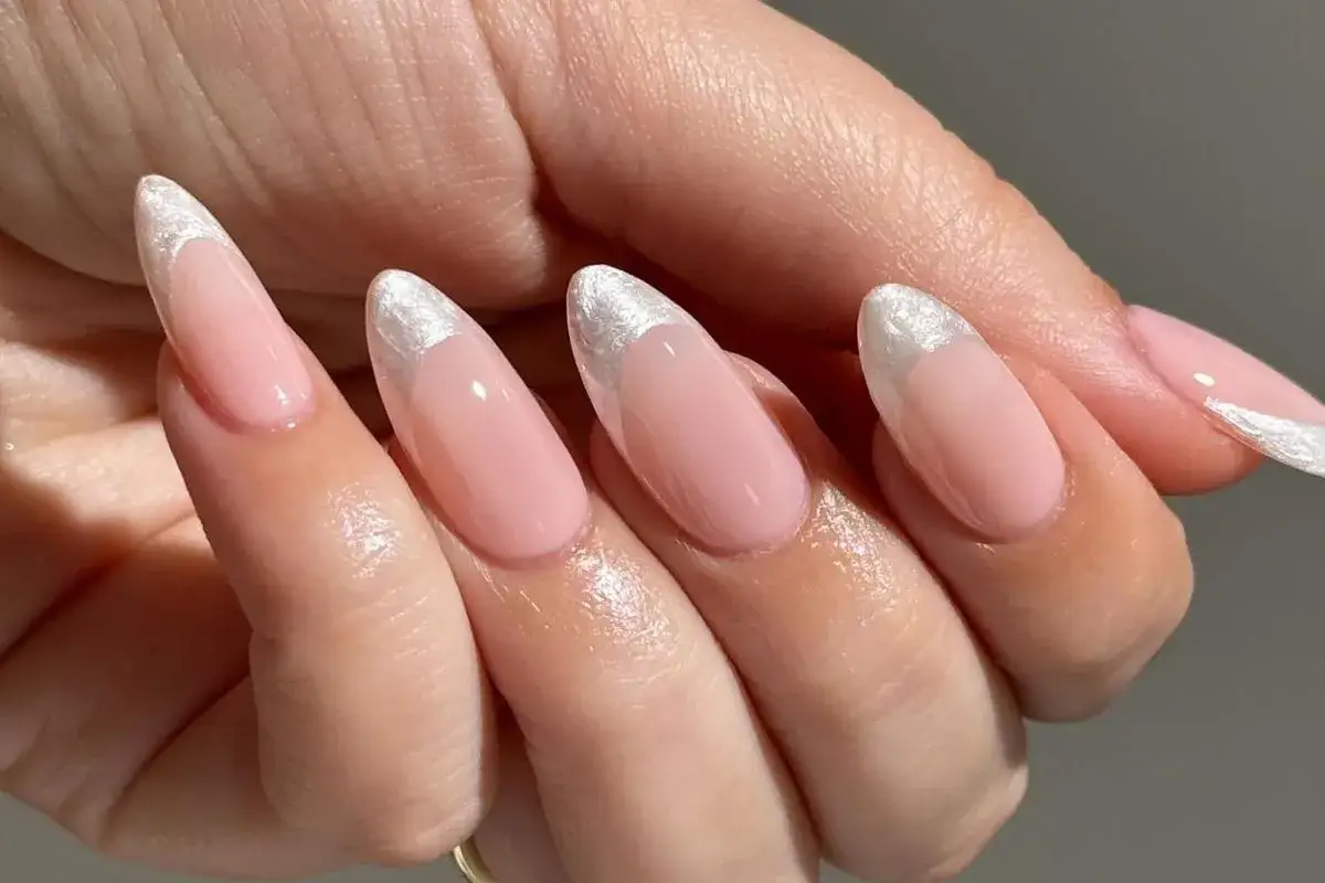 Delikatne, różowe paznokcie w stylu princess nails french z połyskującym, srebrnym wykończeniem na końcówkach.